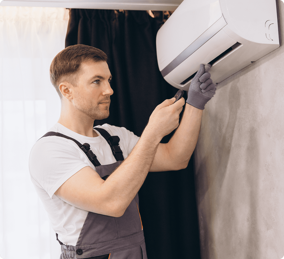 Technician servicing a wall-mounted air conditioner.